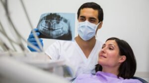 Dentist is diagnosing patient from America who is on Dental Tourism In India
