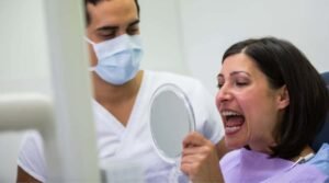 Dentist holding mirror in front of Dental Implant Patient for Any Infections